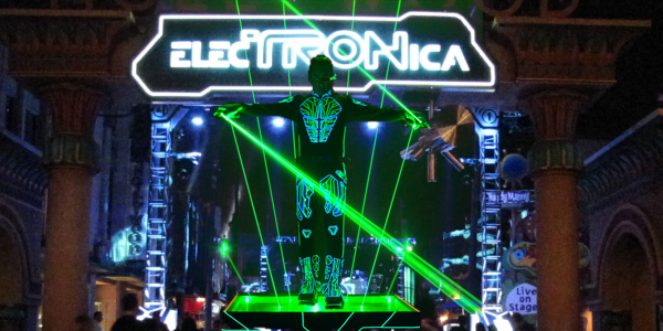 Electronica laser performance with a performer surrounded by green laser beams